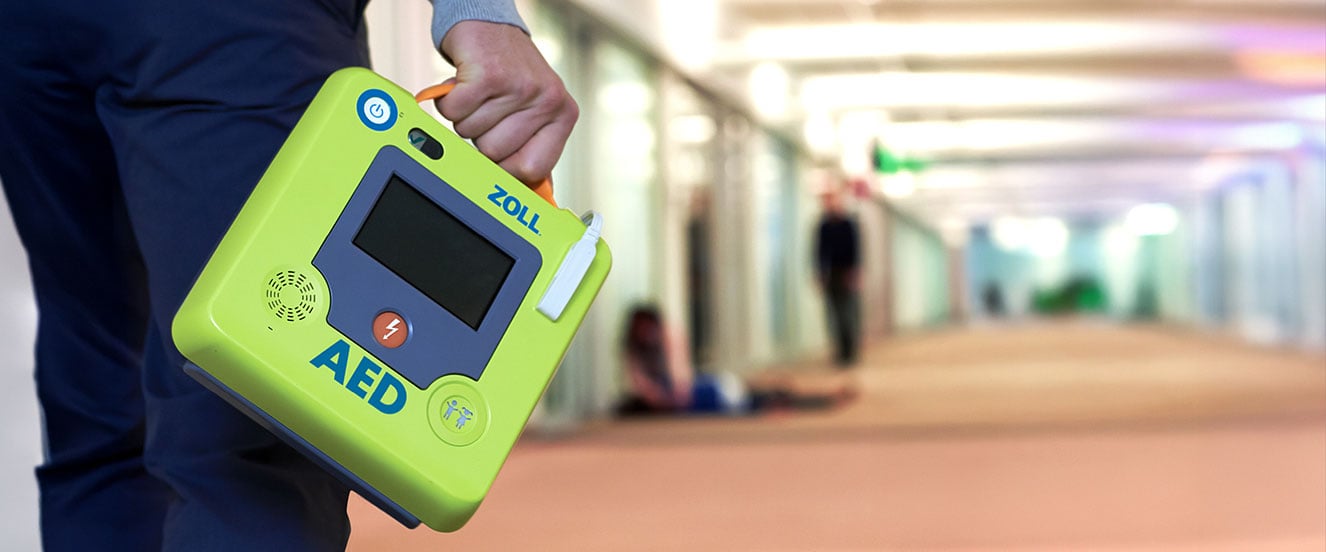 Person carrying AED in hallway | Cintas